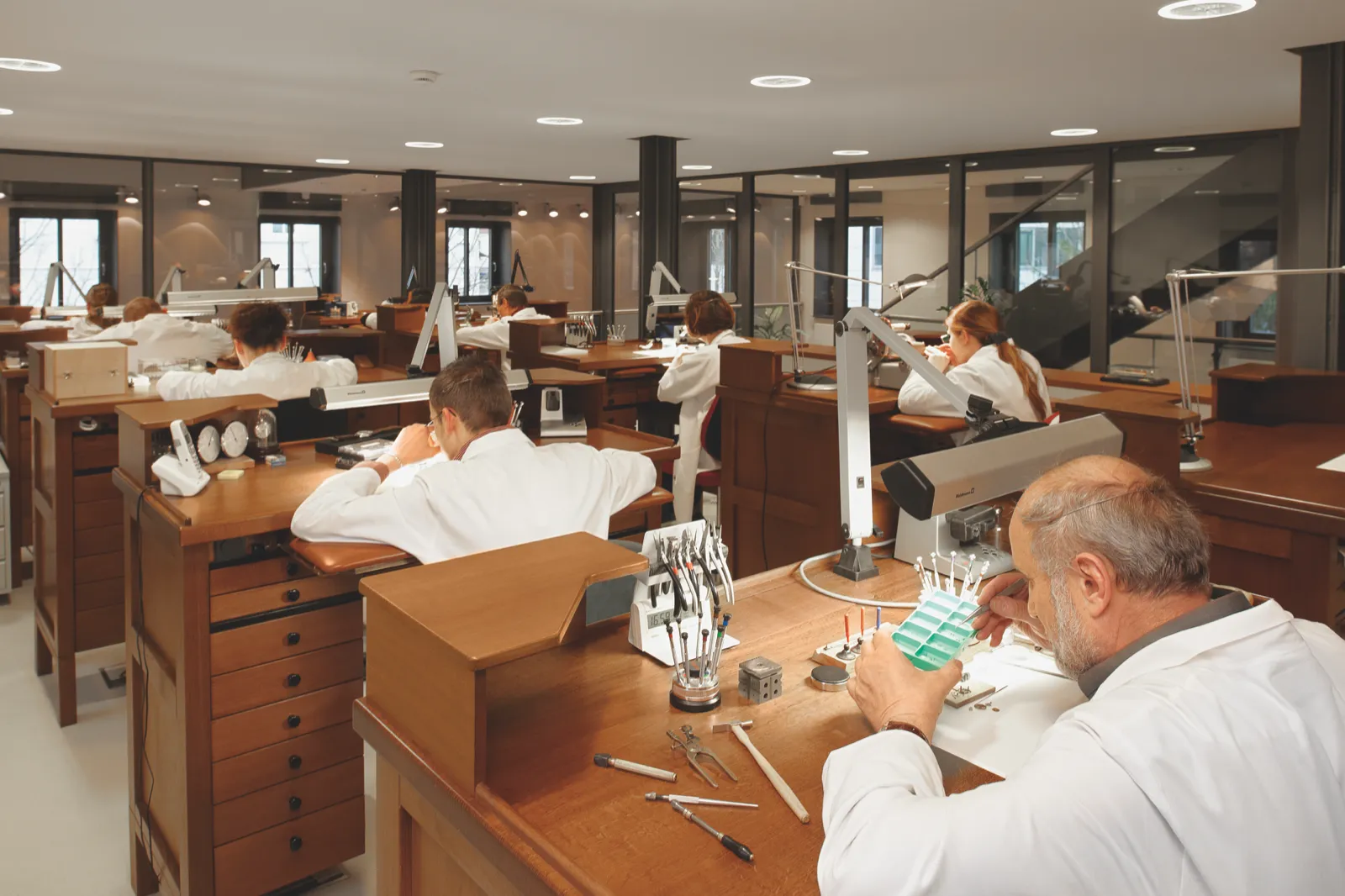 Watchmaking workshop at the Tutima Manufaktur Glashütte — watchmakers in white coats at their benches