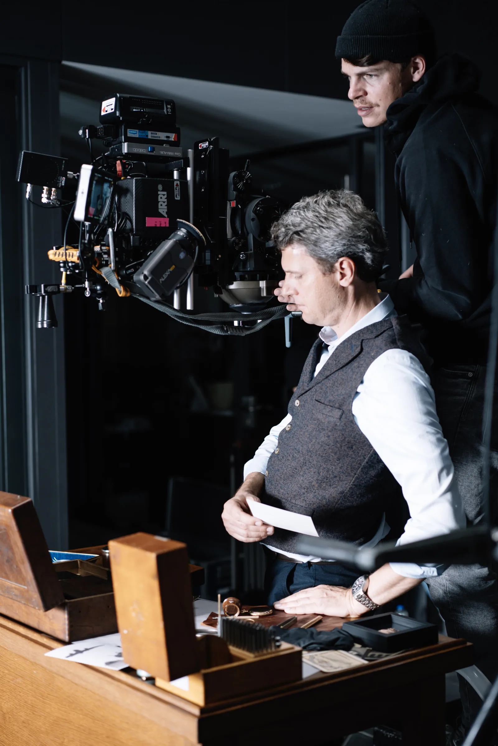 Man at desk with ARRI cinema camera overhead — the world paying attention to the manufactory