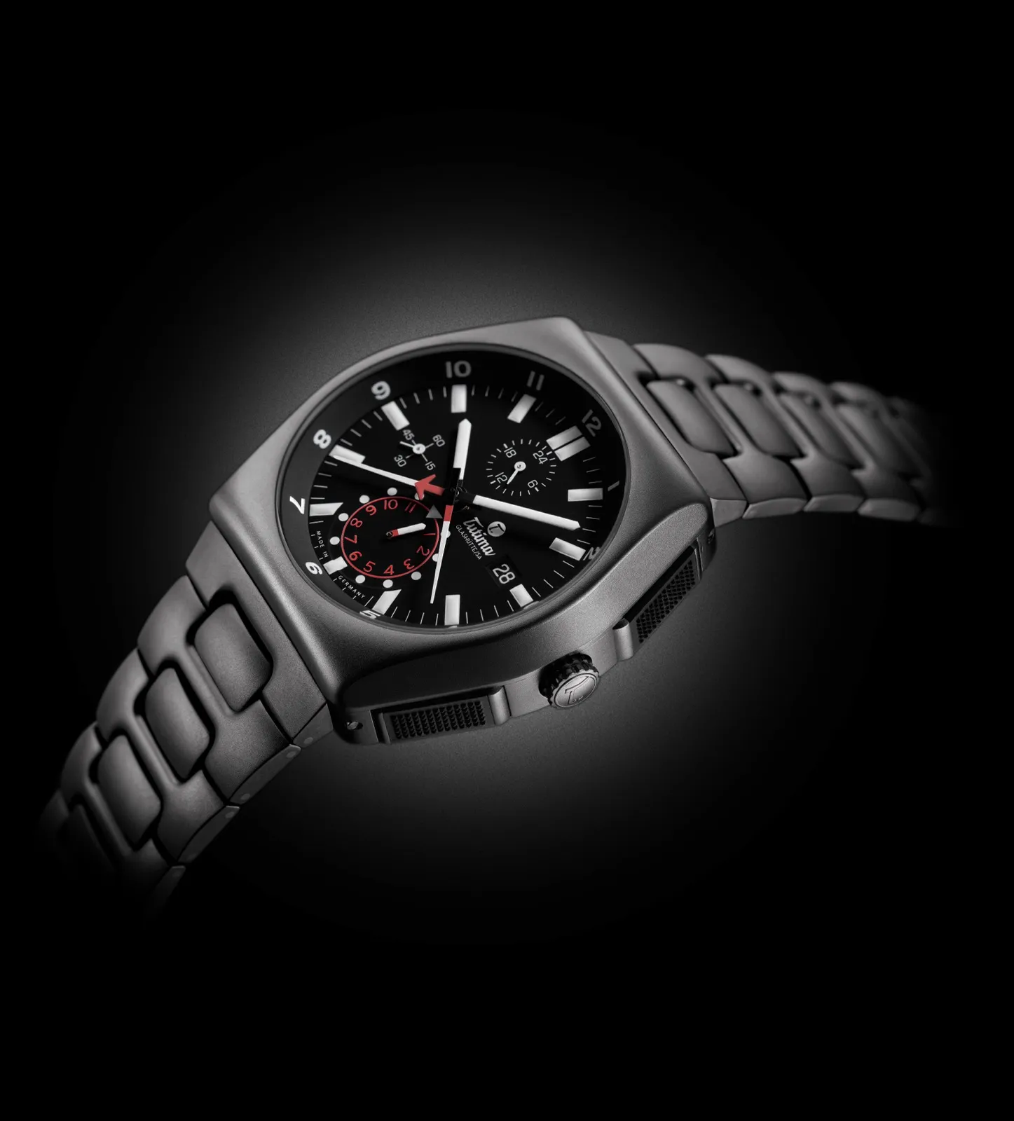 M2 Chronograph — all-black titanium with red accents, dramatic studio lighting